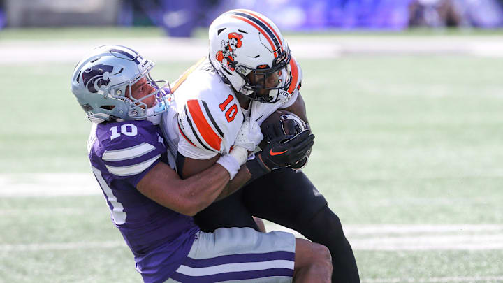 Sep 28, 2024; Manhattan, Kansas, USA; Oklahoma State Cowboys wide receiver Rashod Owens (10) is brought down by Kansas State Wildcats cornerback Jacob Parrish (10) during the second quarter at Bill Snyder Family Football Stadium. Mandatory Credit: Scott Sewell-Imagn Images