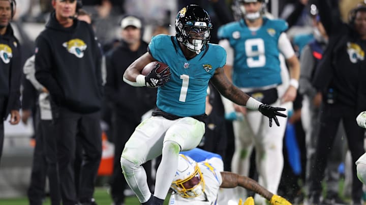Jan 14, 2023; Jacksonville, Florida, USA; Jacksonville Jaguars running back Travis Etienne Jr. (1) runs during the fourth quarter of a wild card game against the Los Angeles Chargers at TIAA Bank Field. Mandatory Credit: Nathan Ray Seebeck-Imagn Images
