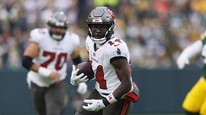 Dec 17, 2023; Green Bay, Wisconsin, USA;  Tampa Bay Buccaneers wide receiver Chris Godwin (14) rushes with the football after catching a pass during the second quarter against the Green Bay Packers at Lambeau Field. Mandatory Credit: Jeff Hanisch-Imagn Images
