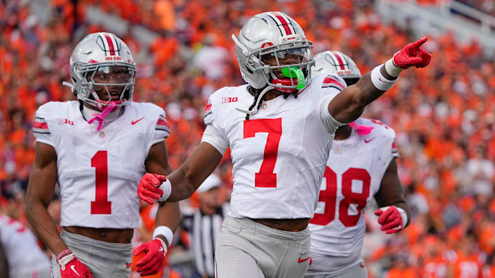 Ohio State Buckeyes cornerback Jermaine Mathews Jr. (7), cornerback Davison Igbinosun (1) and defensive lineman Kayden McDonald (98) celebrate after a fumble by Illinois Fighting Illini quarterback Luke Altmyer (9) during the second half of the NCAA football game at Gies Memorial Stadium in Champaign on Oct. 11, 2025. Ohio State won 34-16.