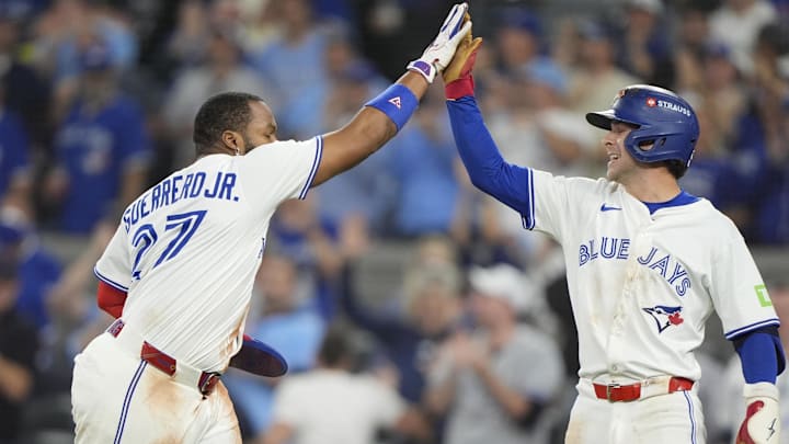 Oct 19, 2025; Toronto, Ontario, CAN; Toronto Blue Jays first baseman Vladimir Guerrero Jr. (27) celebrates after scoring on a throwing error with third baseman Ernie Clement (22) in the seven thinning against the Seattle Mariners during game six of the ALCS round for the 2025 MLB playoffs at Rogers Centre. Oct 19, 2025; Toronto, Ontario, CAN; Toronto Blue Jays first baseman Vladimir Guerrero Jr. (27) celebrates after scoring on a throwing error with third baseman Ernie Clement (22) in the seven thinning against the Seattle Mariners during game six of the ALCS round for the 2025 MLB playoffs at Rogers Centre.