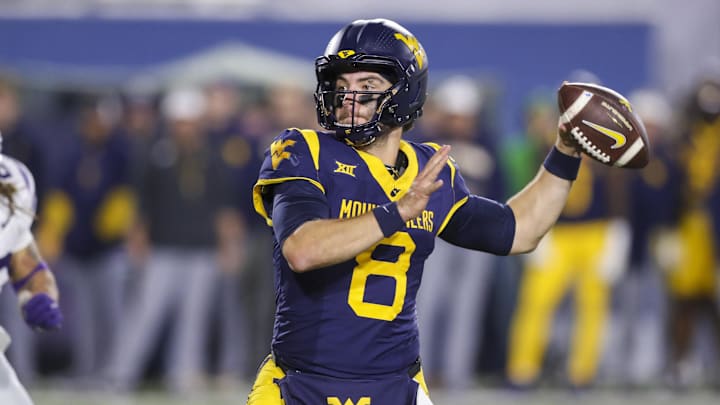 Oct 19, 2024; Morgantown, West Virginia, USA; West Virginia Mountaineers quarterback Nicco Marchiol (8) throws for a touchdown during the fourth quarter against the Kansas State Wildcats at Mountaineer Field at Milan Puskar Stadium. Mandatory Credit: Ben Queen-Imagn Images