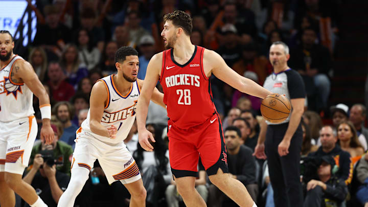 Nov 24, 2025; Phoenix, Arizona, USA; Houston Rockets center Alperen Sengun (28) moves the ball against Phoenix Suns guard Devin Booker (1) in the second half at Mortgage Matchup Center. Mandatory Credit: Mark J. Rebilas-Imagn Images