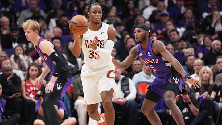 Oct 23, 2024; Toronto, Ontario, CAN; Cleveland Cavaliers forward Isaac Okoro (35) controls the ball as Toronto Raptors guard Immanuel Quickley (5) tries to defend during the second quarter at Scotiabank Arena. Mandatory Credit: Nick Turchiaro-Imagn Images
