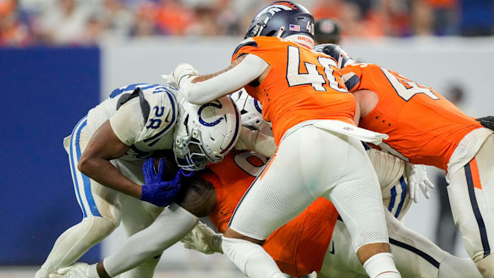 Denver Broncos defenders work to bring down Indianapolis Colts running back Jonathan Taylor (28) on Sunday, Sept. 14, 2025, during a game at Lucas Oil Stadium in Indianapolis.