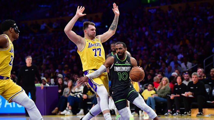 Apr 30, 2025; Los Angeles, California, USA; Minnesota Timberwolves guard Mike Conley (10) moves the ball against Los Angeles Lakers guard Luka Doncic (77) during the second half in game five of first round for the 2025 NBA Playoffs at Crypto.com Arena. Mandatory Credit: Gary A. Vasquez-Imagn Images