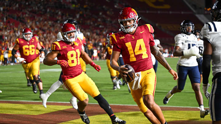 Sep 7, 2024; Los Angeles, California, USA; USC Trojans quarterback Jayden Maiava (14) scores a touchdown against the Utah State Aggies during the fourth quarter at United Airlines Field at Los Angeles Memorial Coliseum. Mandatory Credit: Jonathan Hui-Imagn Images