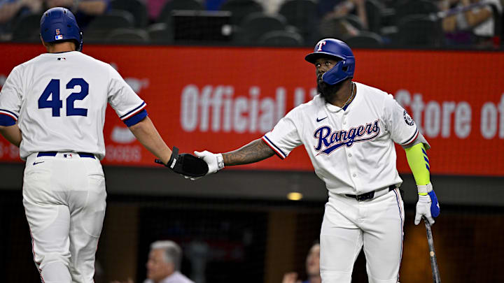 Apr 15, 2025; Arlington, Texas, USA; Texas Rangers shortstop Corey Seager (left) and Texas Rangers right fielder Adolis Garcia (right) celebrates a run scored by Seager against the Los Angeles Angels during the eighth inning at Globe Life Field. 
