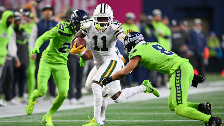 Dec 15, 2024; Seattle, Washington, USA; Green Bay Packers wide receiver Jayden Reed (11) stiff arms Seattle Seahawks cornerback Coby Bryant (8) during the first half at Lumen Field. Mandatory Credit: Steven Bisig-Imagn Images