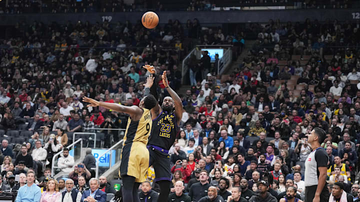 Apr 2, 2024; Toronto, Ontario, CAN; Los Angeles Lakers forward LeBron James (23) shoots the ball at the basket as Toronto Raptors guard RJ Barrett (9) tries to defend during the second quarter at Scotiabank Arena. Mandatory Credit: Nick Turchiaro-Imagn Images.