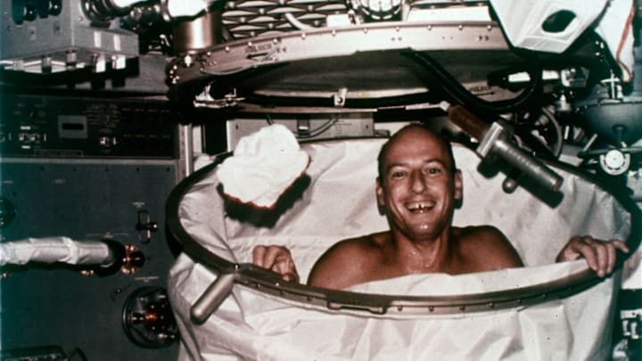 Skylab 2 commander Peter Conrad attempts to take a shower aboard the spacecraft in 1973.