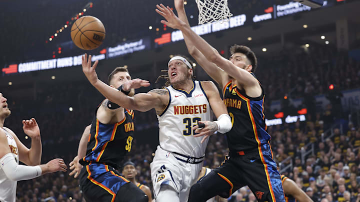 May 7, 2025; Oklahoma City, Oklahoma, USA; Denver Nuggets forward Aaron Gordon (32) shoots from under the basket between Oklahoma City Thunder center Isaiah Hartenstein (55) and forward Chet Holmgren (7) in the first quarter during game two of the second round for the 2025 NBA Playoffs at Paycom Center. Mandatory Credit: Alonzo Adams-Imagn Images