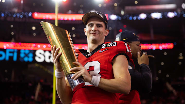 Jan 9, 2023; Inglewood, CA, USA; Georgia Bulldogs quarterback Stetson Bennett (13) celebrates with the championship trophy after defeating the TCU Horned Frogs during the CFP national championship game at SoFi Stadium. Mandatory Credit: Mark J. Rebilas-Imagn Images