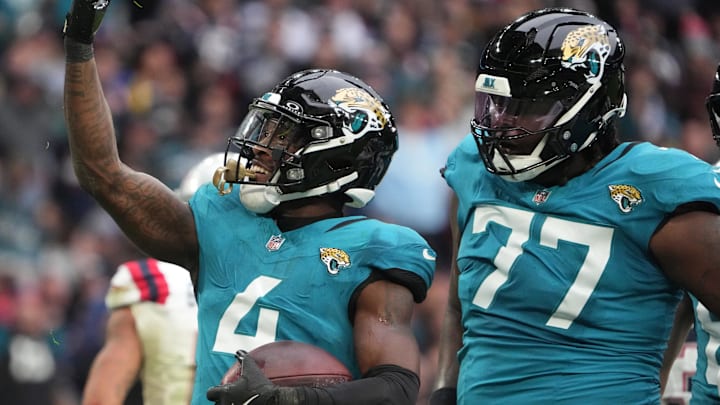 Oct 20, 2024; London, United Kingdom; Jacksonville Jaguars running back Tank Bigsby (4) celebrates with offensive tackle Anton Harrison (77) after scoring on a 1-yard touchdown run against the New England Patriots in the first half of an NFL International Series game at Wembley Stadium. 