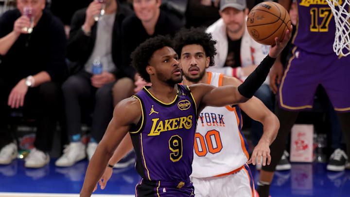 Feb 1, 2025; New York, New York, USA; Los Angeles Lakers guard Bronny James (9) drives to the basket against New York Knicks forward Jacob Toppin (00) and center Ariel Hukporti (55) during the fourth quarter at Madison Square Garden. Mandatory Credit: Brad Penner-Imagn Images