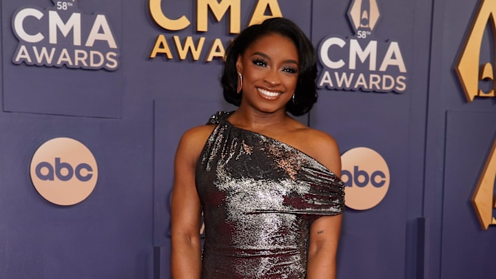 Simone Biles poses on the red carpet before the 58th Annual Country Music Association Awards in Nashville, Tenn.
