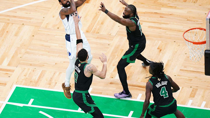 Jun 9, 2024; Boston, Massachusetts, USA; Dallas Mavericks guard Kyrie Irving (11) shoots against Boston Celtics guard Jaylen Brown (7) and forward Jayson Tatum (0) and guard Jrue Holiday (4) in the second quarter during game two of the 2024 NBA Finals at TD Garden. Mandatory Credit: David Butler II-Imagn Images
