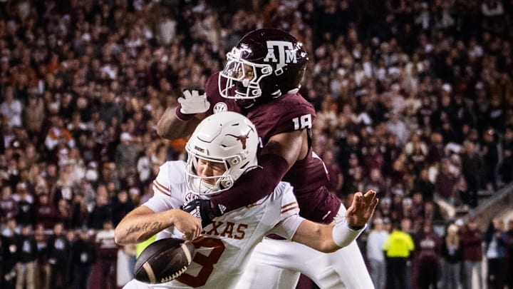 Nov 30, 2024; College Station, Texas, USA; Texas Longhorns quarterback Quinn Ewers (3) is sacked by Texas A&M Aggies defensive lineman Cashius Howell (18) in the third quarter of the Lone Star Showdown at Kyle Field. Mandatory Credit: Sara Diggins/USA TODAY Network via Imagn Images
