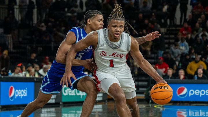Orchard Lake Saint Mary’s Trey McKenney (1) dribbles through IMG Academy’s Darius Acuff (5) at Oakland University in Rochester on Thursday, Jan. 9, 2025.