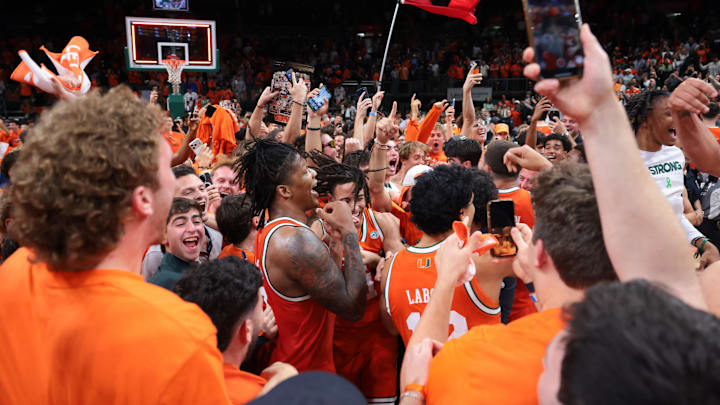 Feb 10, 2026; Coral Gables, Florida, USA; Miami Hurricanes forward Shelton Henderson (7) celebrates with teammates as fans storm the court after the game against the North Carolina Tar Heels at Watsco Center. Mandatory Credit: Sam Navarro-Imagn Images