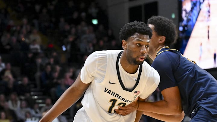 Dec 29, 2025; Nashville, Tennessee, USA;  Vanderbilt Commodores forward Jalen Washington (13) dribbles the ball past New Haven Chargers guard John Oladipo (13) during the first half at Memorial Gymnasium. Mandatory Credit: Steve Roberts-Imagn Images
