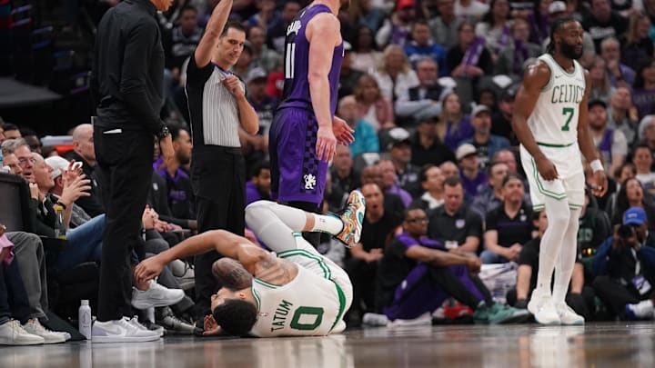Mar 24, 2025; Sacramento, California, USA; Boston Celtics forward Jayson Tatum (0) lays on the ground after suffering an injury next to Sacramento Kings center Domantas Sabonis (11) in the third quarter at the Golden 1 Center. Mandatory Credit: Cary Edmondson-Imagn Images