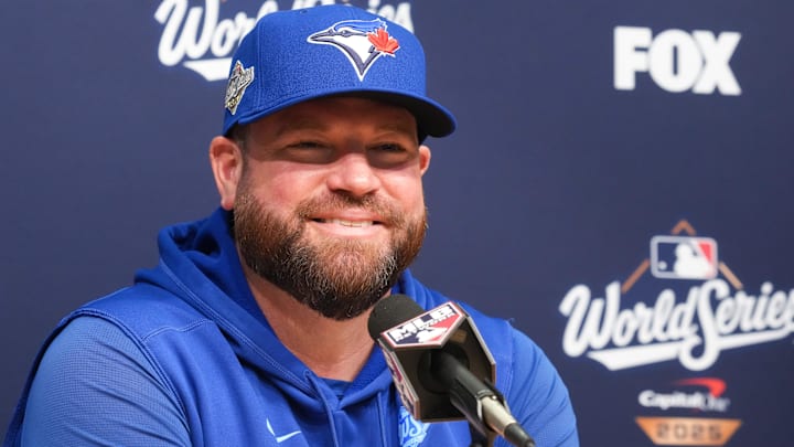 Schneider smiling as he speaks to the press before game five of the World Serie