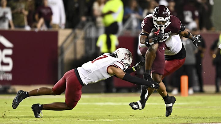 Nov 16, 2024; College Station, Texas, USA; Texas A&M Aggies running back EJ Smith (22) carries the ball during the first half as New Mexico State Aggies cornerback Keonte Glinton (7) and defensive end Justin Beadles (4) defend at Kyle Field. Mandatory Credit: Maria Lysaker-Imagn Images 