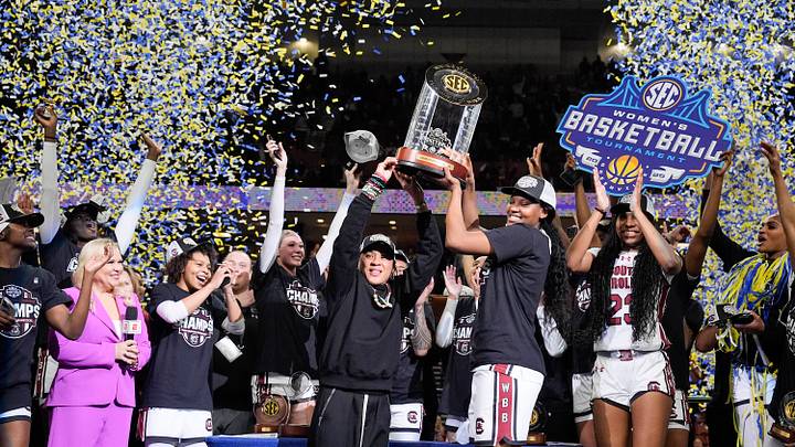 Mar 9, 2025; Greenville, SC, USA;  South Carolina Gamecocks head coach Dawn Staley and forward Sania Feagin (20) hoist the SEC Championship Trophy after her teams win over Texas during the SEC Women’s Tournament at Bon Secours Wellness Arena. Mandatory Credit: Jim Dedmon-Imagn Images
