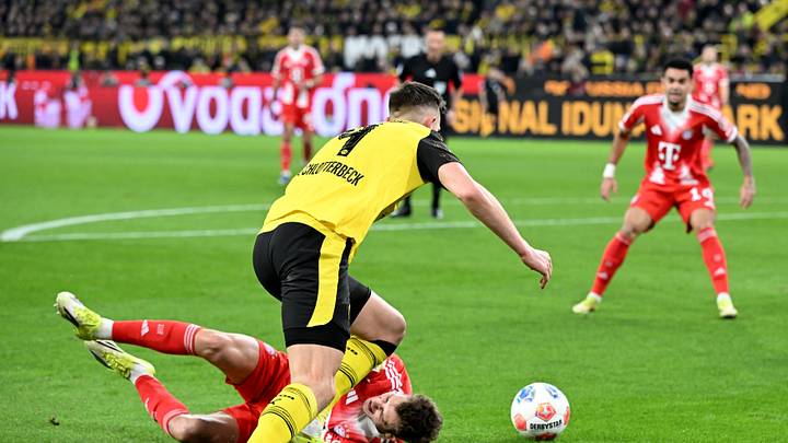 Josip Stanisic geht nach einem Tackling von Nico Schlotterbeck zu Boden
