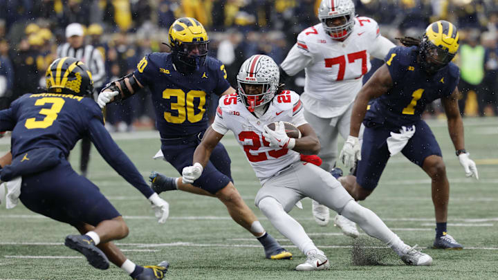 Ohio State Buckeyes running back Bo Jackson runs the ball pressured by Michigan Wolverines linebacker Jimmy Rolder and defensive back Jaden Mangham