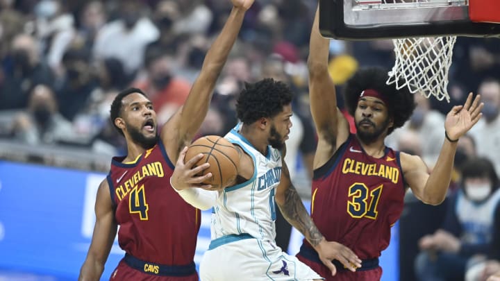 Mar 2, 2022; Cleveland, Ohio, USA; Charlotte Hornets forward Miles Bridges (0) moves between Cleveland Cavaliers center Evan Mobley (4) and center Jarrett Allen (31) in the first quarter at Rocket Mortgage FieldHouse. Mandatory Credit: David Richard-USA TODAY Sports