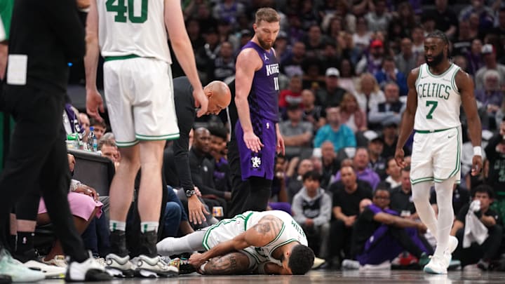 Mar 24, 2025; Sacramento, California, USA; Boston Celtics forward Jayson Tatum (0) lays on the ground after suffering an injury next to Sacramento Kings center Domantas Sabonis (11) in the third quarter at the Golden 1 Center. Mandatory Credit: Cary Edmondson-Imagn Images