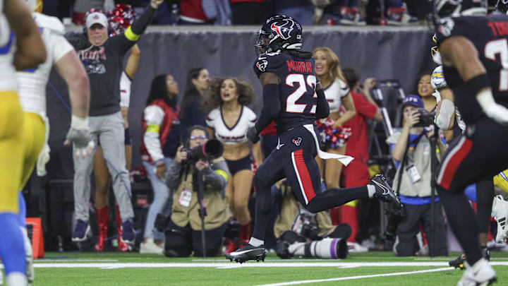 Jan 11, 2025; Houston, Texas, USA; Houston Texans safety Eric Murray (23) returns an interception for a touchdown during the game against the Los Angeles Chargers in an AFC wild card game at NRG Stadium. Mandatory Credit: Troy Taormina-Imagn Images