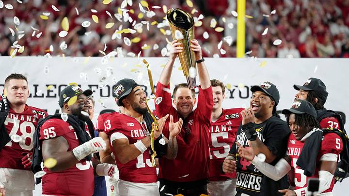 Jan 19, 2026; Miami Gardens, FL, USA; Indiana Hoosiers head coach Curt Cignetti holds up the trophy as the team celebrates winning the College Football Playoff National Championship game at Hard Rock Stadium. Mandatory Credit: Kirby Lee-Imagn Images