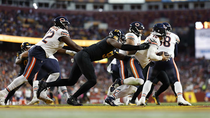 Kiran Amegadjie gets beat on a pass block and Caleb Williams is hit as he throws in Sunday's 18-15 loss to the Commanders.