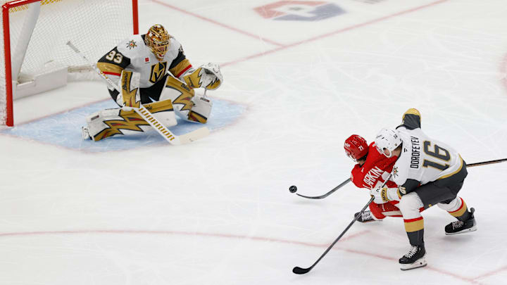 Mar 4, 2026; Detroit, Michigan, USA;  Detroit Red Wings center Dylan Larkin (71) takes a shot on Vegas Golden Knights goaltender Adin Hill (33) defended by right wing Pavel Dorofeyev (16) in the first period at Little Caesars Arena. Mandatory Credit: Rick Osentoski-Imagn Images