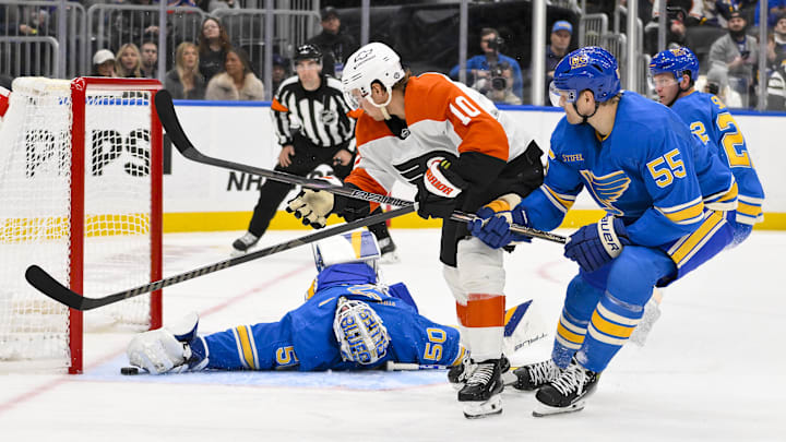 Nov 30, 2024; St. Louis, Missouri, USA;  St. Louis Blues goaltender Jordan Binnington (50) and defenseman Colton Parayko (55) defend the net against Philadelphia Flyers right wing Bobby Brink (10) during the third period at Enterprise Center. Mandatory Credit: Jeff Curry-Imagn Images