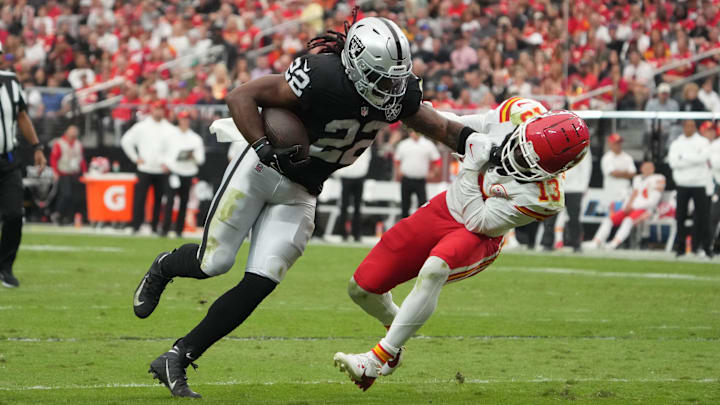 Oct 27, 2024; Paradise, Nevada, USA; Las Vegas Raiders running back Alexander Mattison (22) carries the ball against Kansas City Chiefs running back Clyde Edwards-Helaire (25) in the first half at Allegiant Stadium. Mandatory Credit: Kirby Lee-Imagn Images