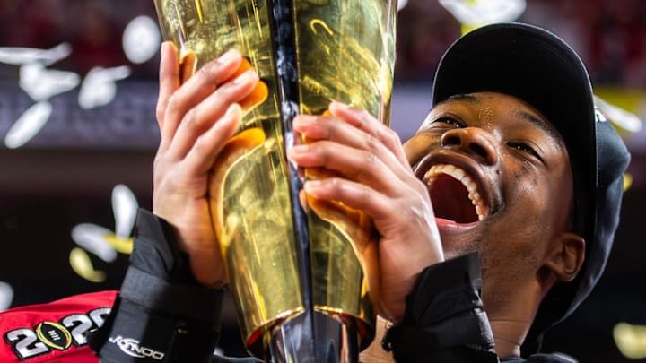 Indiana's Mikail Kamara (6) lifts the trophy on the podium after the College Football Playoff National Championship game.