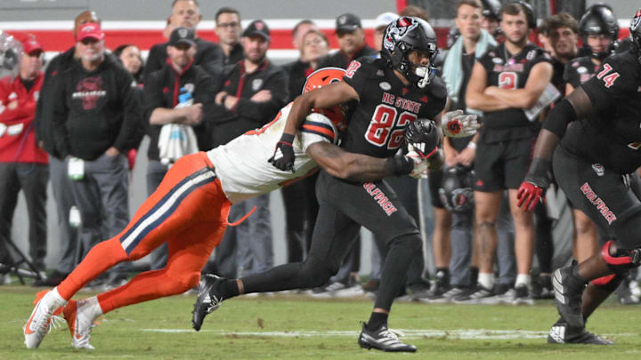 Oct 12, 2024; Raleigh, North Carolina, USA;  North Carolina State Wolfpack wide receiver Keenan Jackson (82) is tackled by Syracuse Orange defensive back Duce Chestnut (0) during the first half of the game at Carter-Finley Stadium. Mandatory Credit: Zachary Taft-Imagn Images