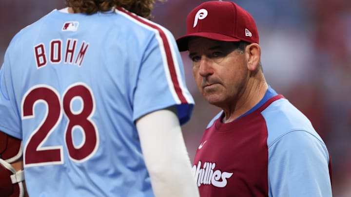  Philadelphia Phillies manager Rob Thomson (R) checks third base Alec Bohm (28) after an apparent injury during the first inning against the Atlanta Braves at Citizens Bank Park.