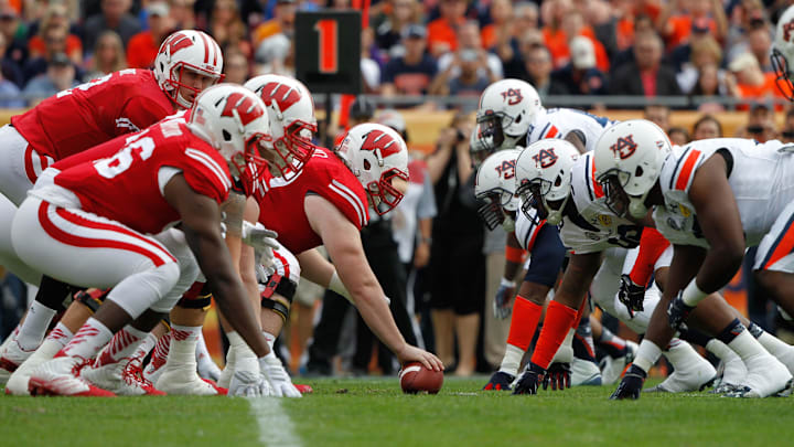 Wisconsin Badgers offensive line and Auburn Tigers defensive line on the line of scrimmage