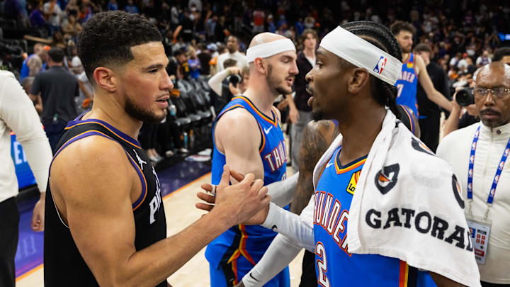 Apr 27, 2026; Phoenix, Arizona, USA; Oklahoma City Thunder guard Shai Gilgeous-Alexander (2) greets Phoenix Suns guard Devin Booker (1) after advancing in a four game sweep of the first round of the 2026 NBA Playoffs at Mortgage Matchup Center. Mandatory Credit: Mark J. Rebilas-Imagn Images