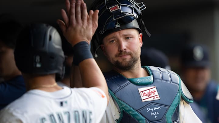 Jul 19, 2025; Seattle, Washington, USA;  Seattle Mariners right fielder Dominic Canzone (8), left, is congratulated by catcher Cal Raleigh (29) in the dugout after hitting a two-run double during the third inning against the Houston Astros at T-Mobile Park. Mandatory Credit: Stephen Brashear-Imagn Images