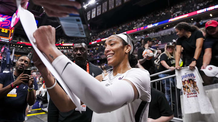 Sep 13, 2024; Indianapolis, Indiana, USA; Las Vegas Aces center A'ja Wilson (22) signs a poster Friday, Sept. 13, 2024, during a game between the Indiana Fever and the Las Vegas Aces on Friday, Sept. 13, 2024, at Gainbridge Fieldhouse in Indianapolis. The Aces defeated the Fever, 78-74.  Mandatory Credit: Grace Smith/USA TODAY Network via Imagn Images