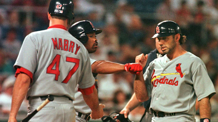 Gary Gaetti (R) is greeted at the plate by St. Louis Cardinals teammates