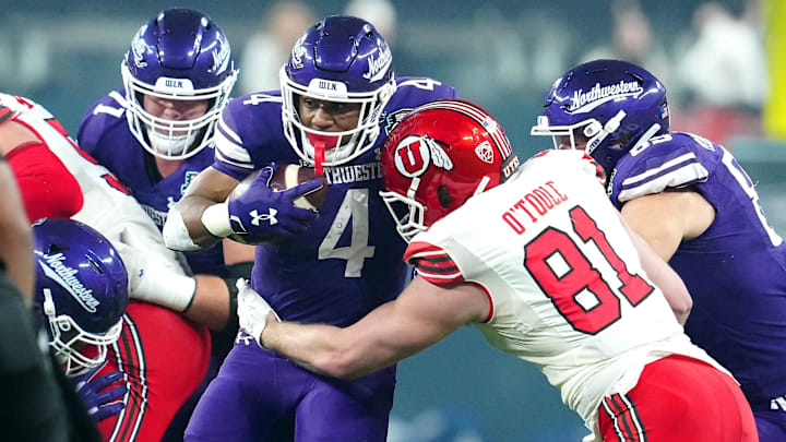 Northwestern Wildcats running back Cam Porter is tackled by Utah Utes defensive end Connor O'Toole.