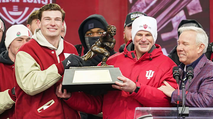 Indiana Hoosiers quarterback Fernando Mendoza (15) holds the Heisman Trophy with Indiana Hoosiers head coach Curt Cignetti on Saturday, Jan. 24, 2026, during the Indiana Football College Football Playoff National Championship celebration and parade at Memorial Stadium in Bloomington.