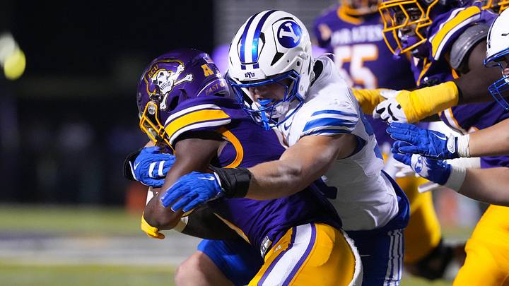Sep 20, 2025; Greenville, North Carolina, USA;  East Carolina Pirates running back Parker Jenkins (5) is stopped on his run by Brigham Young Cougars defensive end Hunter Clegg (90) during the second half at Dowdy-Ficklen Stadium. Mandatory Credit: James Guillory-Imagn Images